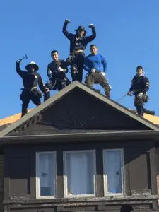 Our roofing experts posing while on a house’s roof