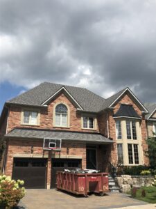 A house with brick exteriors and a dark gray roof